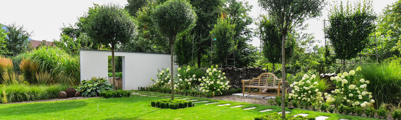 Gartenparadies | © Adobe Stock 284379076 Wunderschöner Garten mit grünem Rasen, Bäume und einer Gartenbank. | © Adobe Stock 284379076