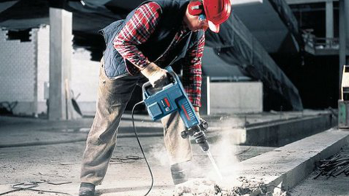 Im Bild stemmt ein Mann mit einem Bosch Gerät den Boden auf.